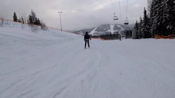 Első személyű kilátás a síelőkre és a snowboardosokra Slide Down on Ski Slope at Ski Resort — Stock videók