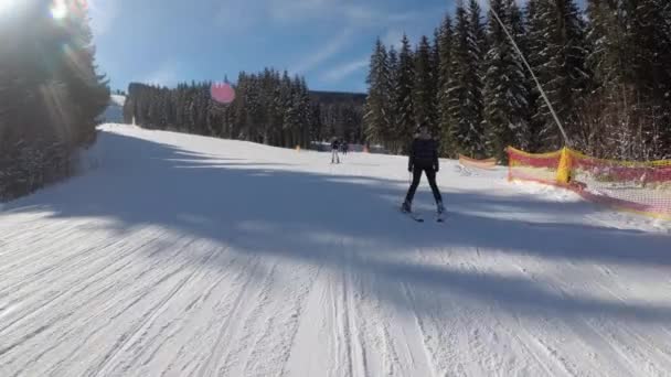 POV Principiante ragazza sugli sci e sciatori dilettanti scivolare giù sulla pista da sci presso la stazione sciistica — Video Stock