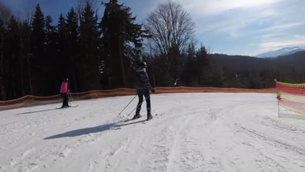 Pov Začátečník dívka na lyžích a amatéři skluzavka dolů na sjezdovce v lyžařském středisku — Stock video