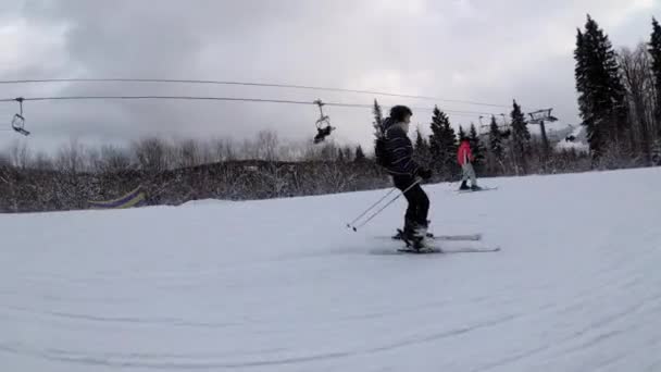 POV Principiante ragazza sugli sci e sciatori dilettanti scivolare giù sulla pista da sci presso la stazione sciistica contro il sole — Video Stock