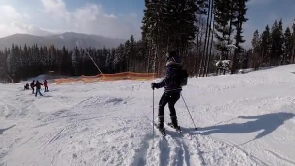 Vista en primera persona de los esquiadores aficionados y snowboarders que se deslizan por la pista de esquí en la estación de esquí — Vídeos de Stock