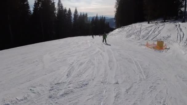 Deslice hacia abajo en la pista de esquí en la estación de esquí. Vista de POV sobre esquiadores y snowboarders — Vídeos de Stock