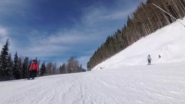 POV Downhill Esqui no Ski Slope em uma estação de esqui. Pessoas esquiando em uma encosta — Vídeo de Stock