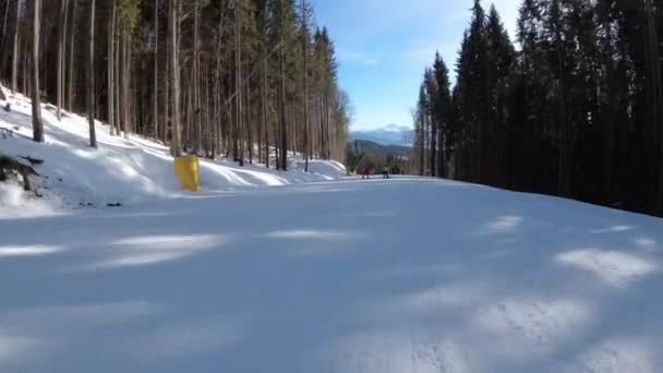 Widok pierwszej osoby na narciarzy i snowboardzistów zjeżdżalnia na stoku narciarskim w ośrodku narciarskim — Wideo stockowe