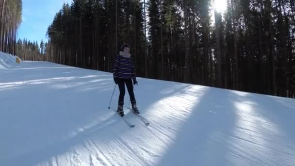 POV Débutant Fille sur les skis et les skieurs amateurs glisser vers le bas sur la piste de ski à la station de ski contre le soleil — Video