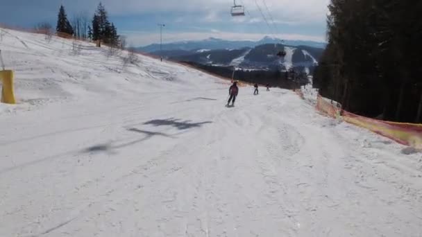 Vista in prima persona su sciatori e snowboarder Scivolare giù sulla pista da sci presso la stazione sciistica — Video Stock
