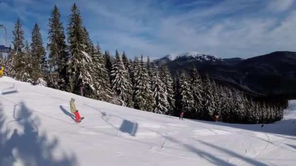 Pov från skidstolslyft till snöig skidbacke, skidåkare glider på skidbacke. — Stockvideo