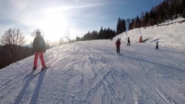 Pohled první osoby na amatérské lyžaře klouzat dolů na sjezdovce v lyžařském středisku — Stock video