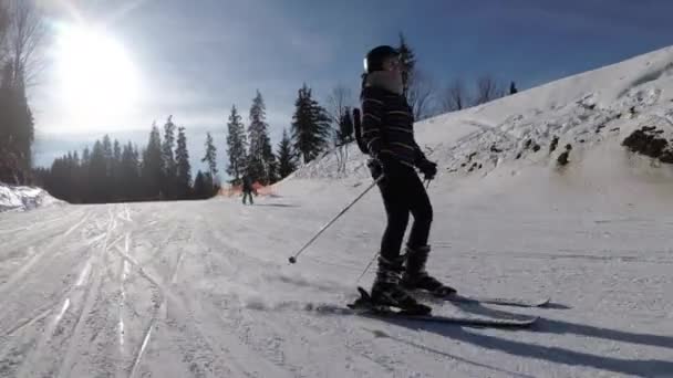 POV Beginner Girl on Skis and Amateur Skiers Deslize para baixo na encosta de esqui no resort de esqui contra o sol — Vídeo de Stock