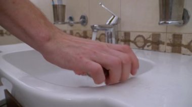 Adam lavaboda ellerini yıkama sabunuyla yıkıyor. Korunma Coronavirüsü