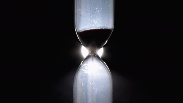 Hourglass on a Black Background. Close-up. Sand moves through the Sandglass — Stock Video