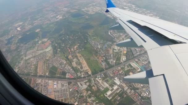 Blick aus dem Fenster eines Düsenflugzeugs auf die Stadtlandschaft Bangkoks — Stockvideo