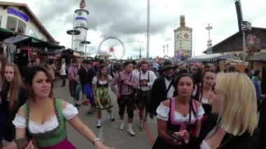 Kamera, Oktoberfest festivalinin merkez caddesindeki Kalabalık 'tan hareket ediyor. Bavyera, Almanya