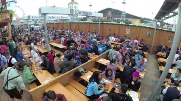 People at the table celebrate Oktoberfest in a large beer bar on the street. Bavaria, Germany — Stock Video