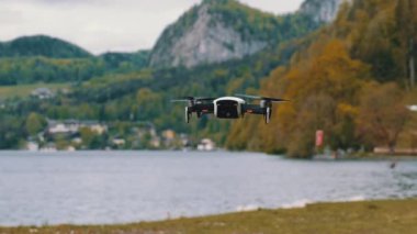 Göl ve Dağların Arkasında Havada Asılı Dönen Pervaneli Drone