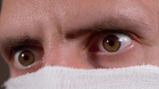 Porträt eines jungen Mannes mit schützender Gaze-Maske, Schutzkoronavirus COVID-19 — Stockvideo