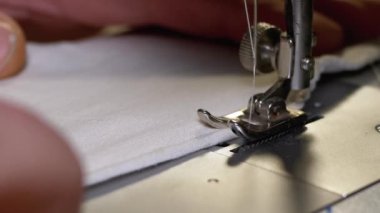 Dikiş Makinesindeki Terzi Covid-19 'u korumak için Ev Yapımı Tıbbi Yüz Maskesi Dikiyor