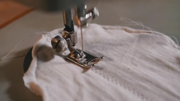 Naaimachine naalden in beweging. Een tailor naait zelfgemaakte gezichtsmasker van stof — Stockvideo
