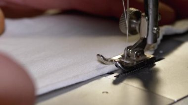 Dikiş Makinesindeki Terzi Covid-19 'u korumak için Ev Yapımı Tıbbi Yüz Maskesi Dikiyor