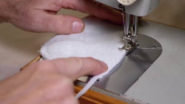 Tailor bij naaimachine naait een zelfgemaakte medische gezichtsmasker om Covid-19 te beschermen — Stockvideo