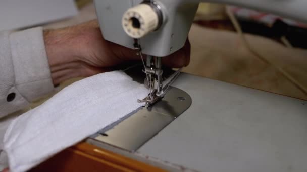Alfaiate na máquina de costura costura costura uma máscara facial médica caseira para proteger Covid-19 — Vídeo de Stock