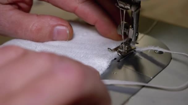 Sastre en la máquina de coser cose una máscara facial médica casera para proteger Covid-19 — Vídeo de stock