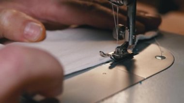 Dikiş Makinesindeki Terzi Covid-19 'u korumak için Ev Yapımı Tıbbi Yüz Maskesi Dikiyor