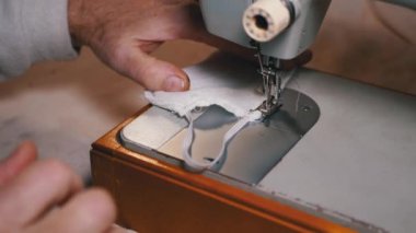 Dikiş Makinesindeki Terzi Covid-19 'u korumak için Ev Yapımı Tıbbi Yüz Maskesi Dikiyor