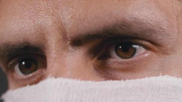 Porträt eines jungen Mannes mit schützender Gaze-Maske, Schutzkoronavirus COVID-19 — Stockvideo