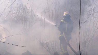 Ekipmandaki itfaiyeciler yangın söndürme hortumuyla söndürüyorlar. Yavaş Hareket