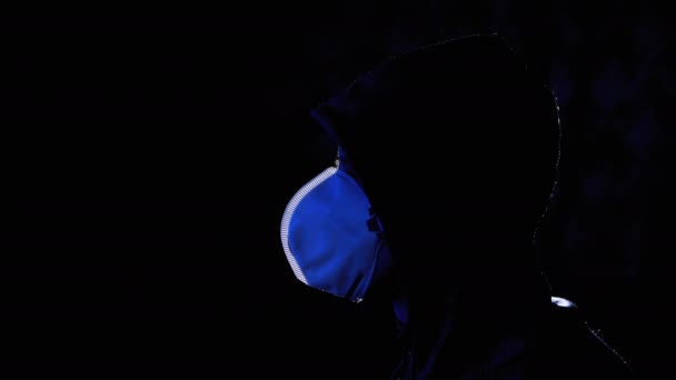 Silhouet van Man in Hood en Medical Mask TV kijken met nepnieuws. Covid-19 — Stockvideo