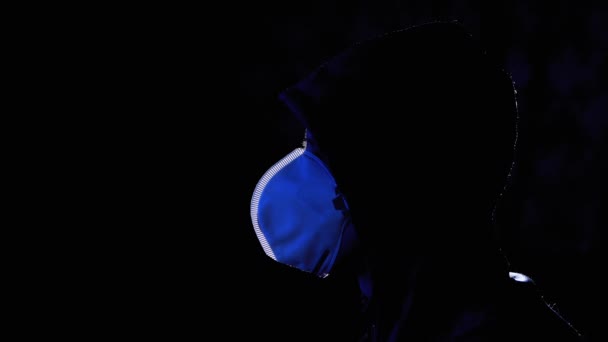 Silhouette of Man in Hood and Medical Mask Assistir TV com notícias falsas. Covid-19 — Vídeo de Stock