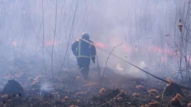 Ekipmandaki itfaiyeciler yangın söndürme hortumuyla söndürüyorlar. Yavaş Hareket