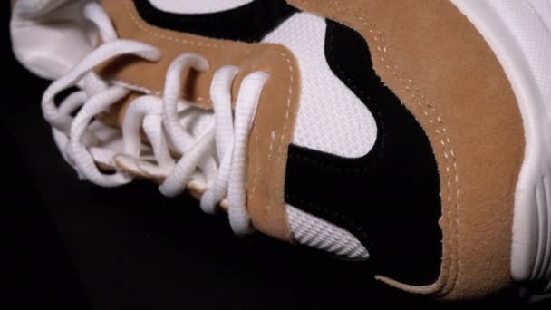 Νέο sneaker περιστρέφεται σε μαύρο φόντο. Αθλητικά γυναικεία κομψά παπούτσια — Αρχείο Βίντεο