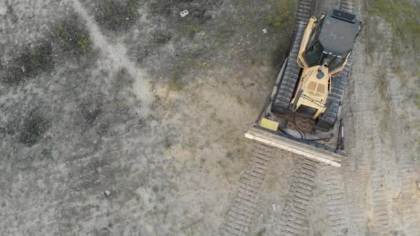 Vista aérea superior en los paseos de Bulldozer rastreados en Sandy Road en el sitio de construcción — Vídeo de stock