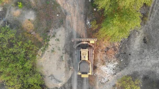 Top Aerial view on Tracked Bulldozer Rides on Sandy Road at Construction Site — Stock Video