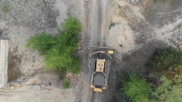 Κορυφή Αεροφωτογραφία στην Tracked Bulldozer Rides στην Sandy Road στο εργοτάξιο — Αρχείο Βίντεο