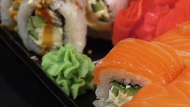 Sushi gira en la caja de plástico. Set de rollos de sushi japonés Philadelphia, California — Vídeo de stock
