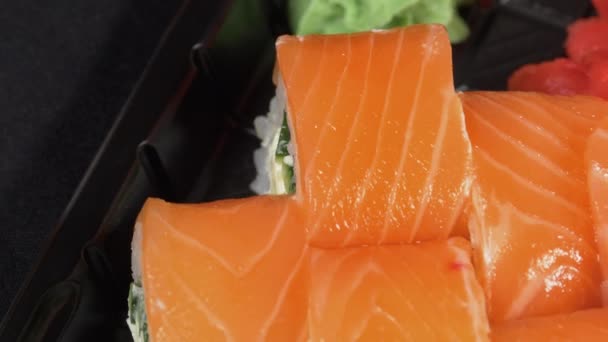 Sushi roterar på en plastlåda. Japanska Sushi Roll Set Philadelphia med lax — Stockvideo