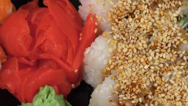 Sushi gira em caixa de plástico. Conjunto japonês de rolos de sushi Filadélfia, Califórnia — Vídeo de Stock