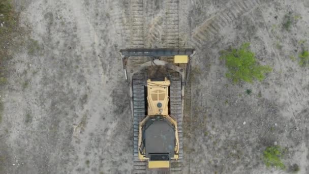 Top Aerial view on Tracked Bulldozer Rides on Sandy Road at Construction Site — Stock video