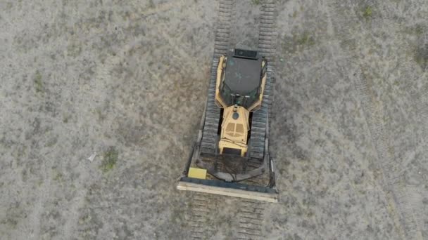 Top Aerial view on Tracked Bulldozer Rides on Sandy Road at Construction Site — Stock Video