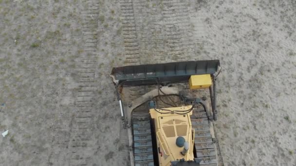 Top Aerial view on Tracked Bulldozer Rides on Sandy Road at Construction Site — Stock video