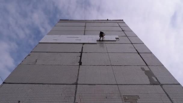 Izolacja elewacyjna starego budynku wysokoregałowego przy użyciu styropianu — Wideo stockowe