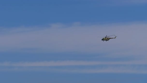 Vrtulník letí na modrém nebi nízko nad zemí — Stock video