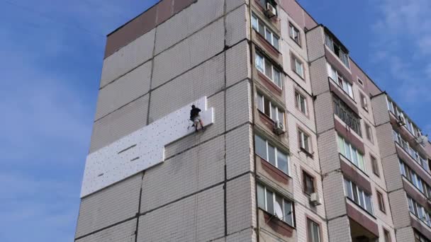 Isolamento industrial do escalador da fachada velho edifício de alta ascensão usando isopor — Vídeo de Stock