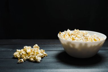 Tuzlu popcorn beyaz bir tabak içinde yatıyor. Sinema, watc kavramı