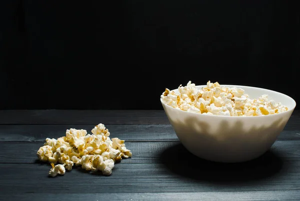 Salziges Popcorn liegt auf einem weißen Teller. das Konzept des Kinos, — Stockfoto