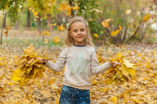 Маленька дівчинка з букетом осіннього листя — стокове фото