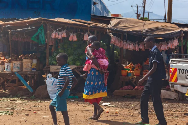 Una mujer camina por la calle y se sostiene en la parte posterior del niño, pe —  Fotos de Stock